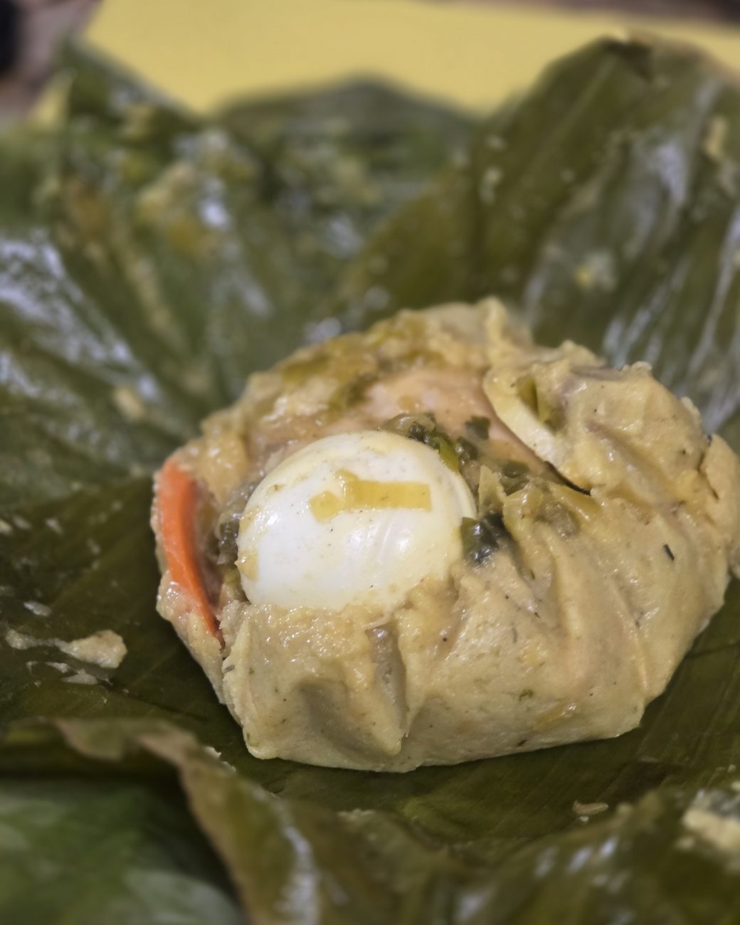 Tamal tolimense desenvuelto, mostrando el relleno de arroz, pollo, cerdo y huevo